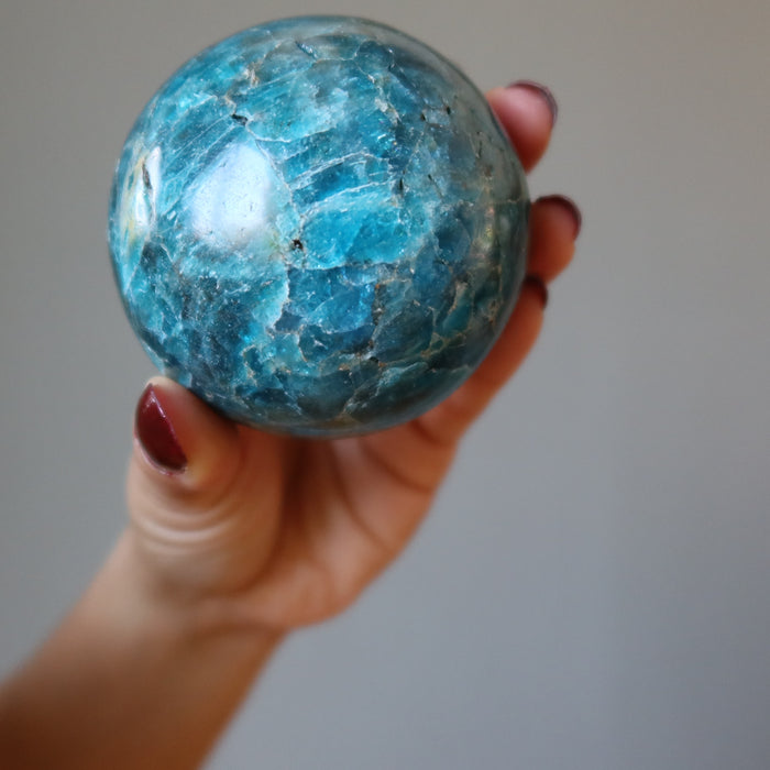 hand holding up an apatite sphere