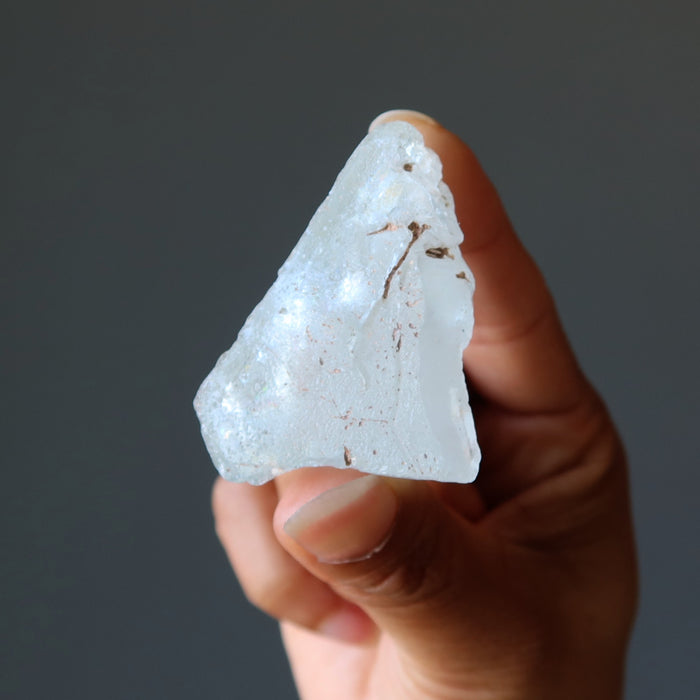 holding one raw aquamarine gemstone