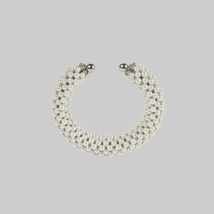 Handcrafted modular bracelet cuff from syntethic japanese pearl on neutral background up view