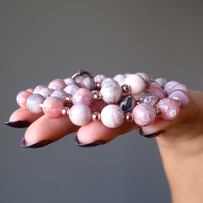hand holding rhodochrosite necklace