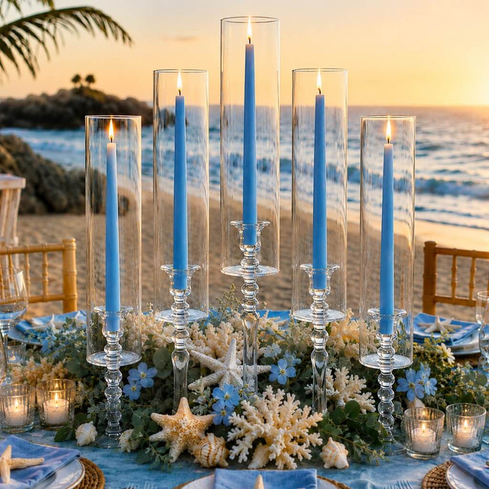 Light blue taper candles in glass holders on elegant beachside dinner table decor