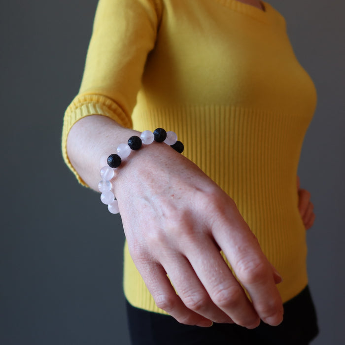 pink rose quartz and black lava stretch bracelet on the wrist of a woman