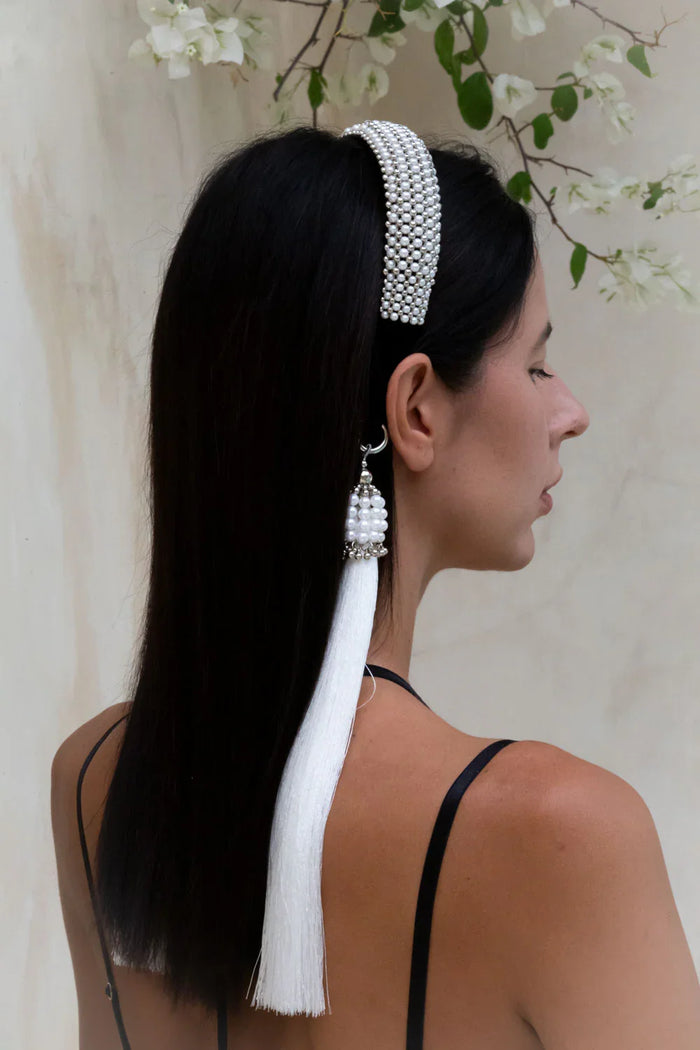 woman in black outfit wear handcrafted beaded modular headband with polyester tassels by object and dawn back view