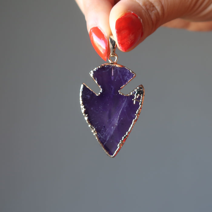 holding purple Arrowhead gold plated framed Amethyst Pendant
