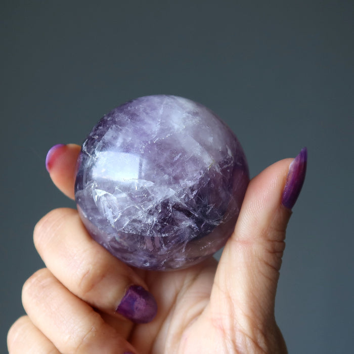 hand holding amethyst sphere