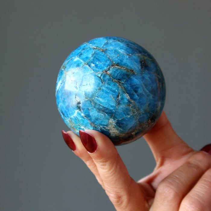 hand holding up an apatite sphere