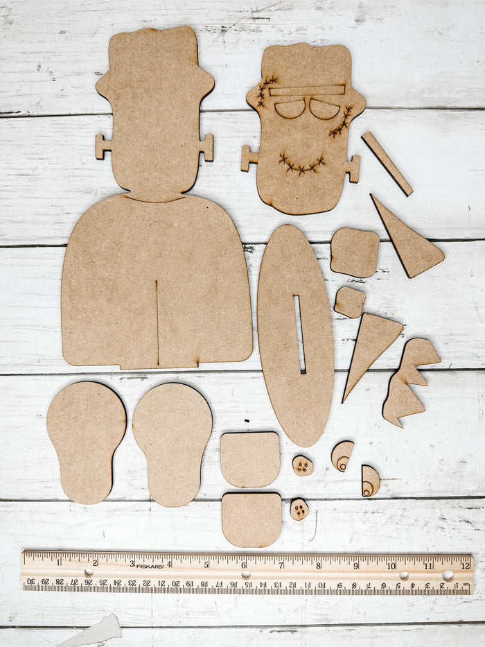 Unassembled Frankenstein wooden DIY kit pieces displayed with a ruler to show the finished size