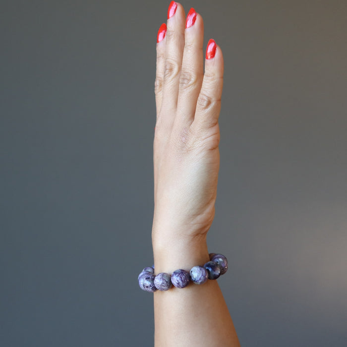 female hand modeling purple charoite stretch bracelet