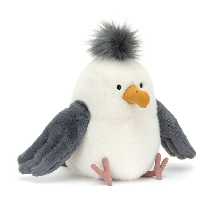 Jellycat Chip Seagull plush toy with a round white body, fluffy grey pom-pom crest, yellow beak, grey wings spread wide, and pink webbed feet, facing slightly right on a white background