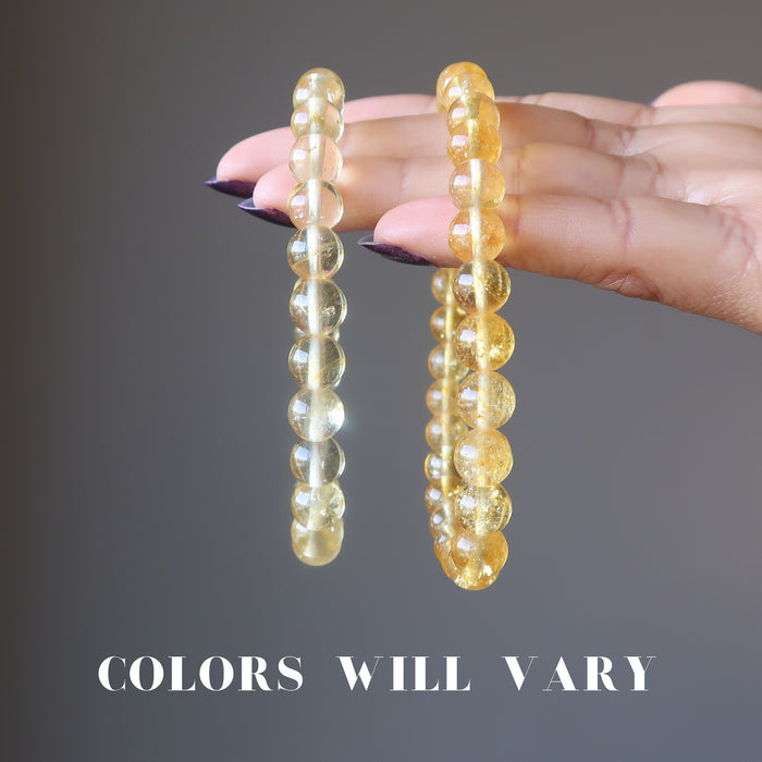 hand holding a light and a dark yellow citrine bracelet to show colors vary