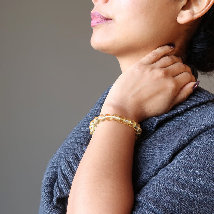 female hand modeling yellow citrine beaded stretch bracelet