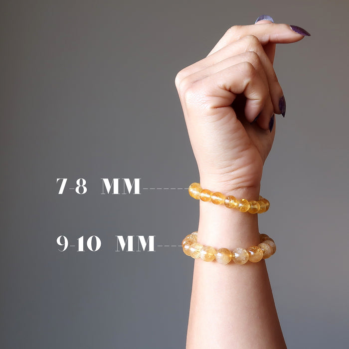 female hand modeling 2 yellow citrine beaded stretch bracelets in different bead sizes