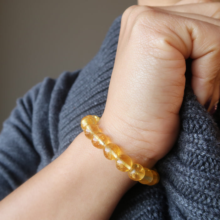 female hand modeling yellow citrine beaded stretch bracelet