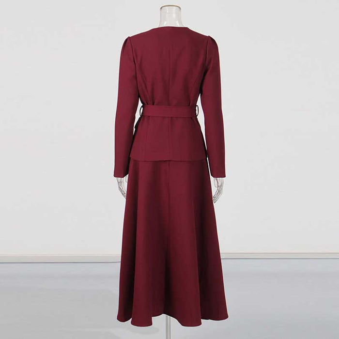Back view of collarless women's midi skirt set in burgundy with a fitted blazer and flowing skirt