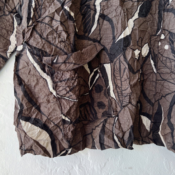 Brown fabric with leaf pattern draped over a white surface