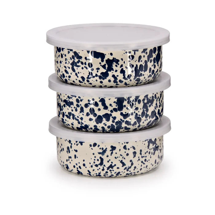 Stack of three ceramic bowls with blue speckled pattern on a white background