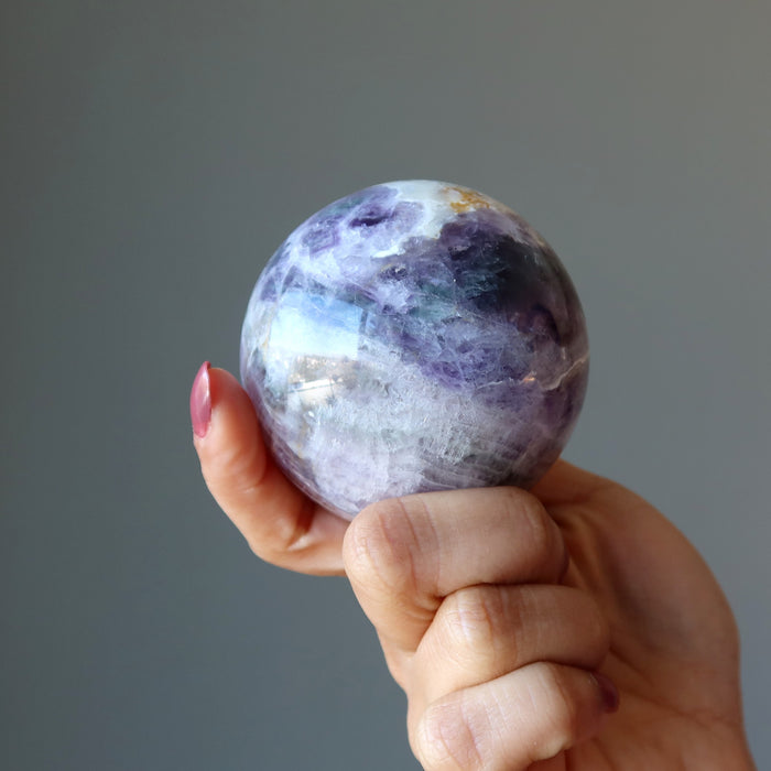 holding purple rainbow Fluorite Sphere