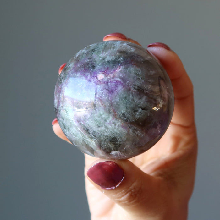 holding purple rainbow Fluorite Sphere