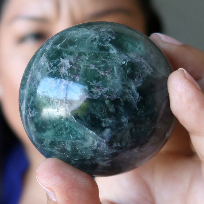 model holding green purple rainbow Fluorite Sphere