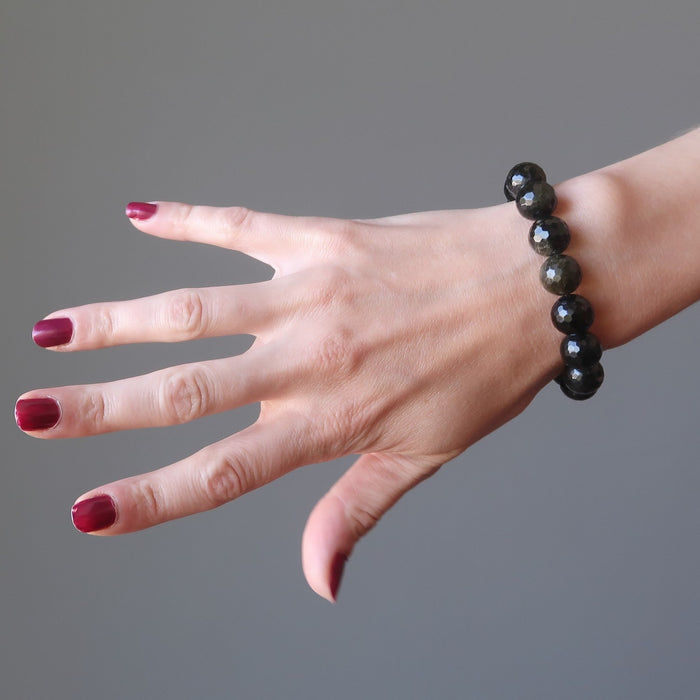 female hand modeling faceted gold sheen obsidian bracelet