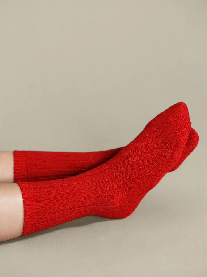 Italia Cashmere Cozy Rib Crew socks in Scarlet — bold red ribbed cashmere crew worn slouched at the ankle with legs raised against a warm grey background