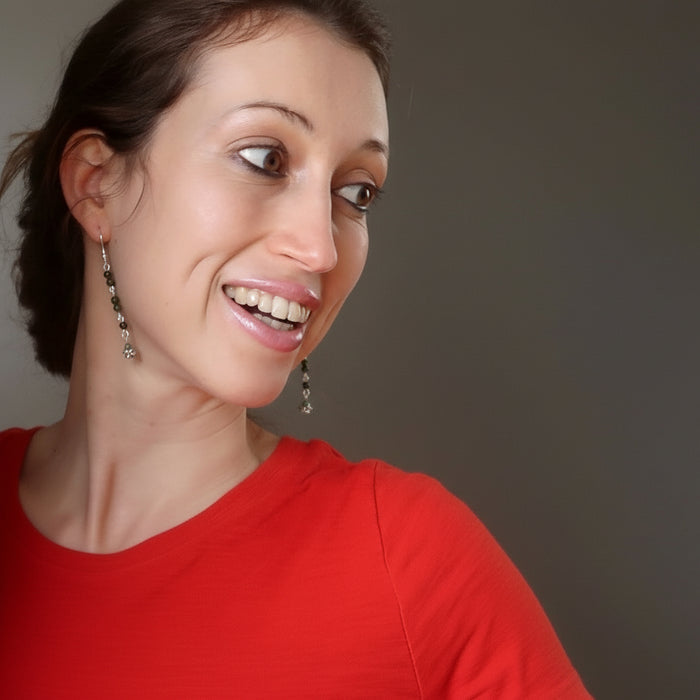 woman modeling jade skull earrings