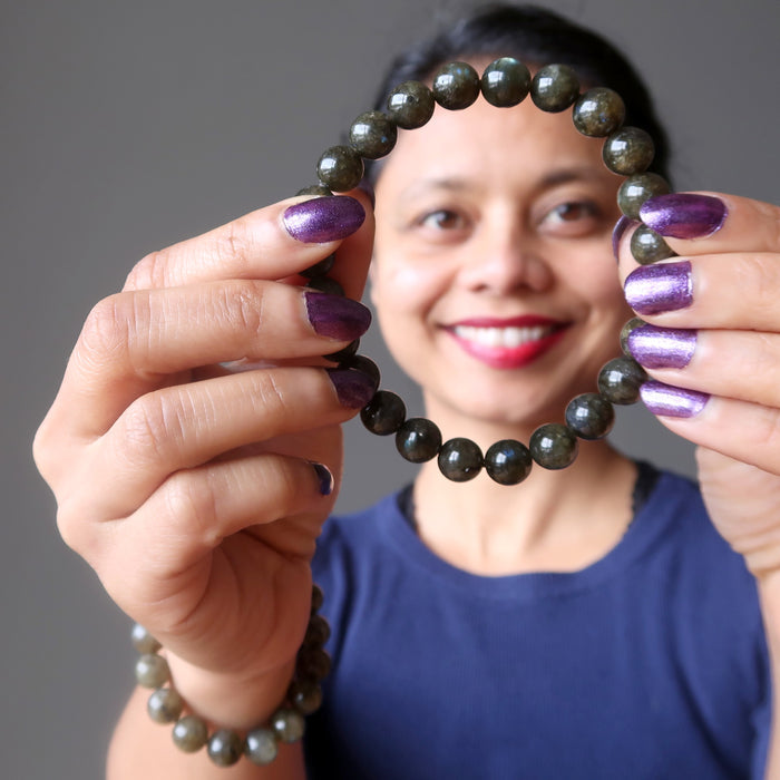 sheila of satin crystals wearing and showing off a round labradorite beaded stretch bracelet