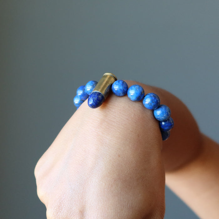 hand making a fist wearing a lapis peace bullet stretch bracelet