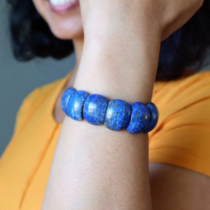 Person wearing a blue Lapis bracelet on a blurred background