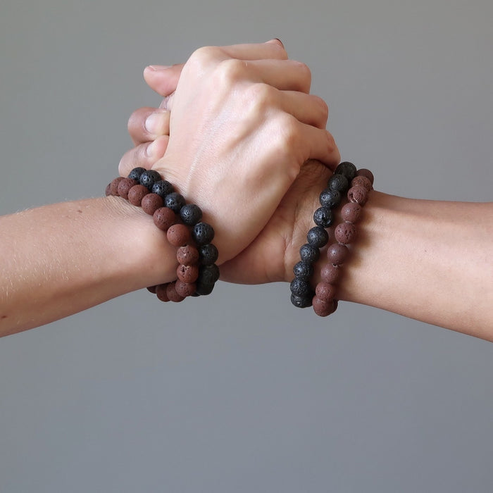 woman and mans clasped together both wearing red and black lava bracelet sets