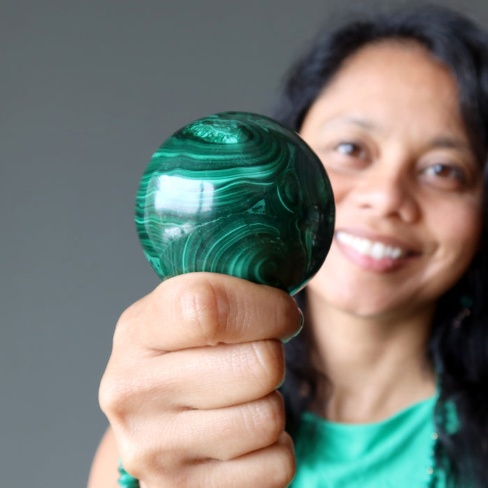 sheila of satin crystals holding a malachite sphere