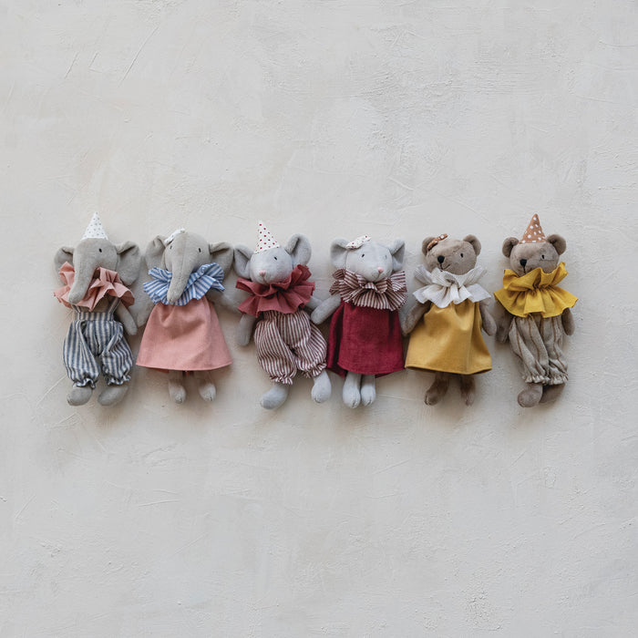 Row of small elephant toys in various outfits on a light background