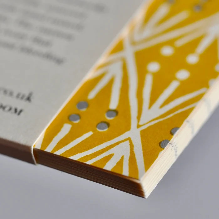 Close-up of a book with a decorative yellow and white pattern on the edge.