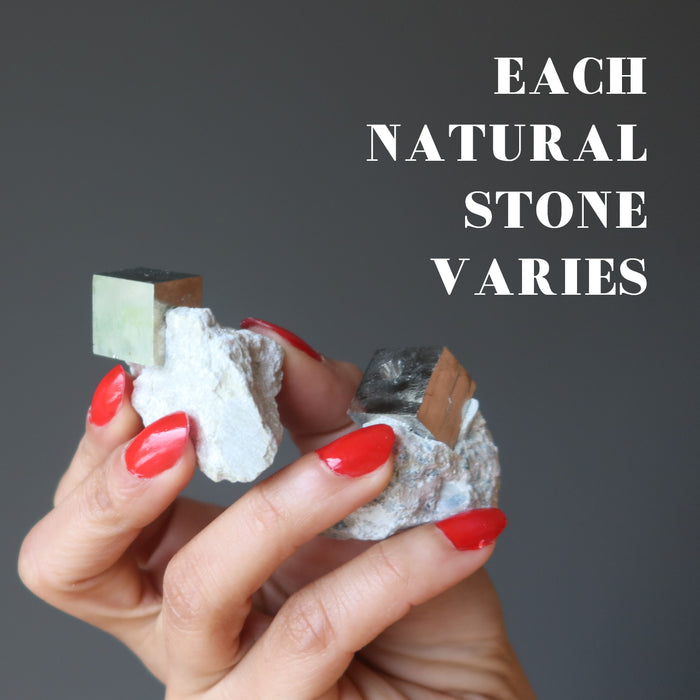 hand holding pyrite cubes to show each natural stone varies