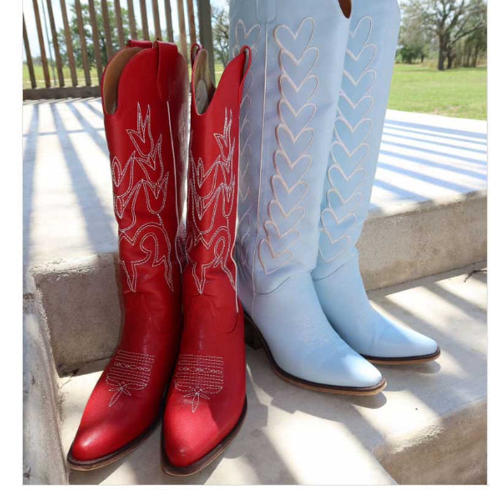 Stylish red chunky cowgirl boots for women displayed alongside blue boots in a sunny outdoor setting
