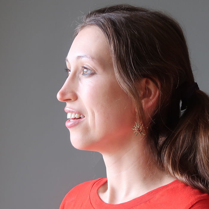 woman wearing red jasper stone earrings with sun-shaped designs