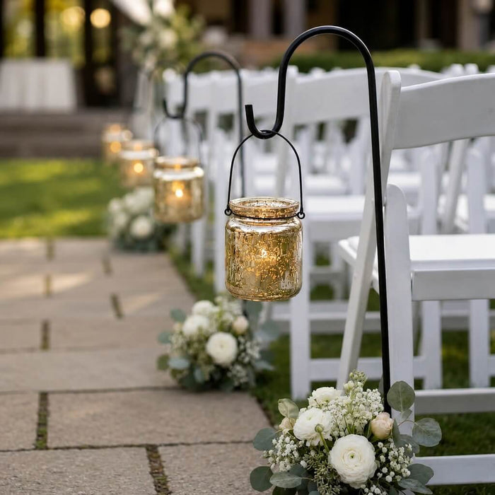 Gold mercury glass hanging holders lining a wedding aisle with white chairs and floral bouquets