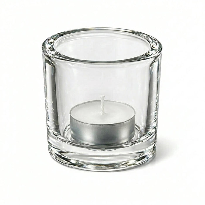 Clear glass candle holder with white tealight candle on white background