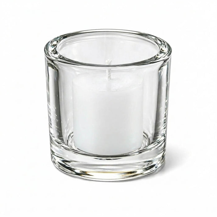 Clear glass candle holder with white votive candle on white background