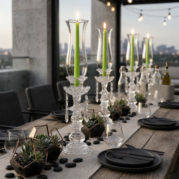 Green taper candles in crystal holders on elegant rooftop dining table