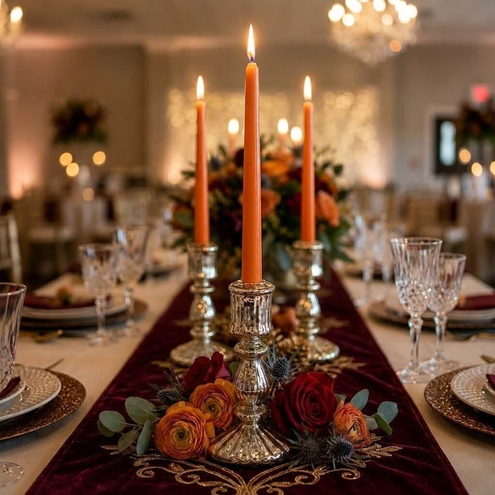Romantic autumn table setting with orange candles and floral centerpiece
