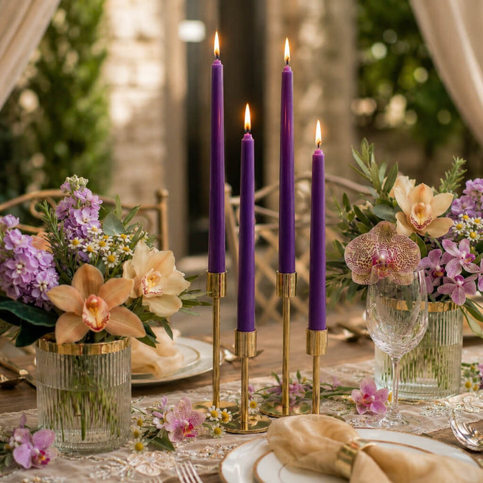 Lit purple taper candles with orchids and pastel floral table decor
