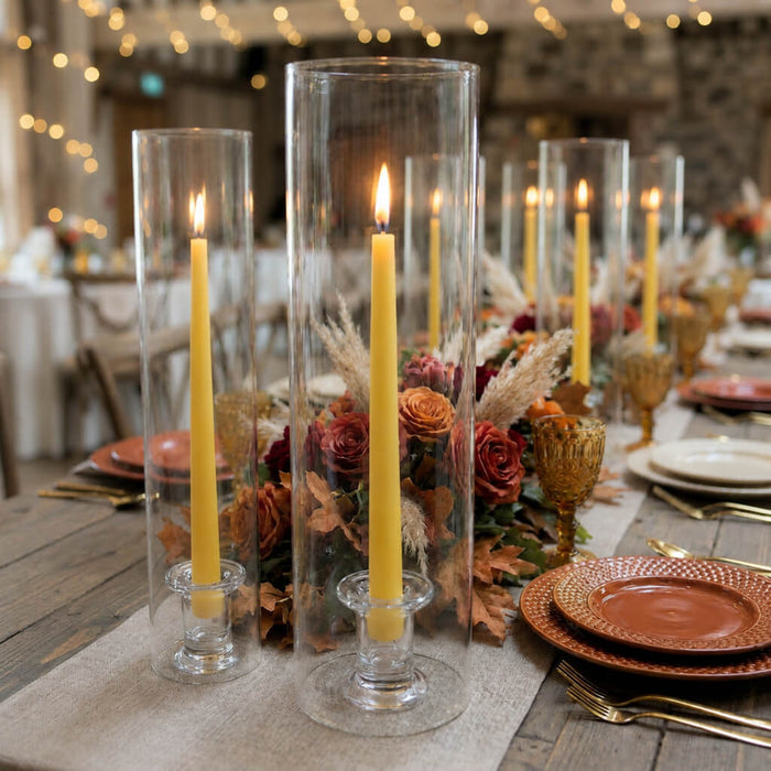 Fall tablescape with yellow candles, florals, and glass hurricane vases