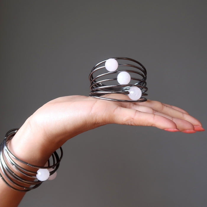 Sheila of Satin Crystals holds one Rose Quartz memory bracelet in hand and wears another on her wrist