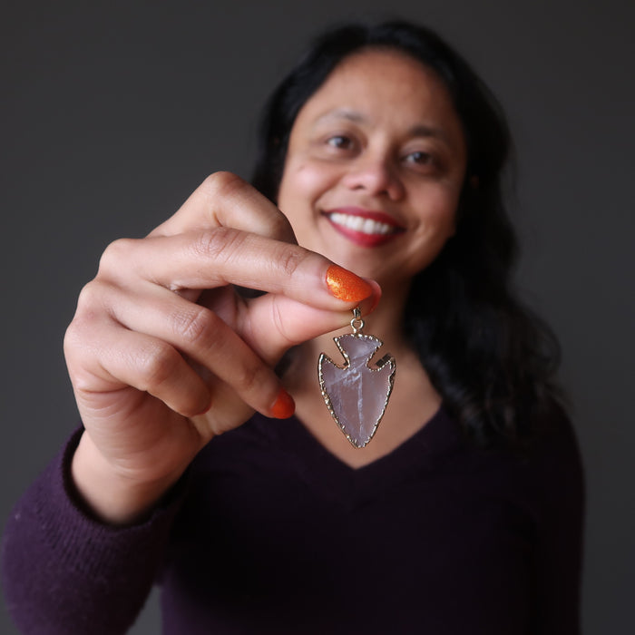 sheila of satin crystals holding a rose quartz arrowhead pendant
