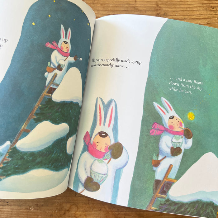 Illustrated book open to a page with characters in winter clothing on a snowy background.