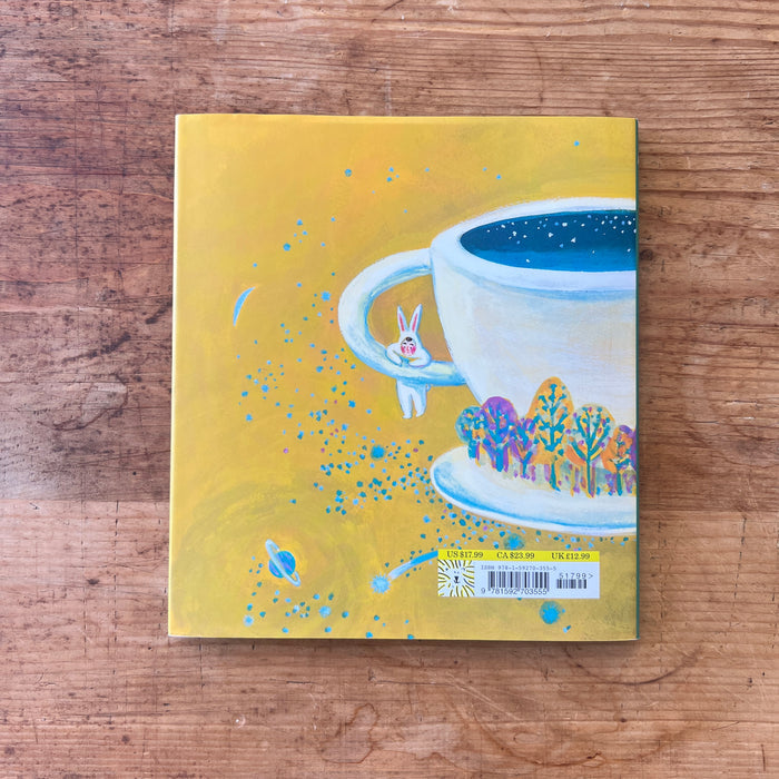 The back cover with a colorful illustration of a teacup and rabbit on a wooden surface