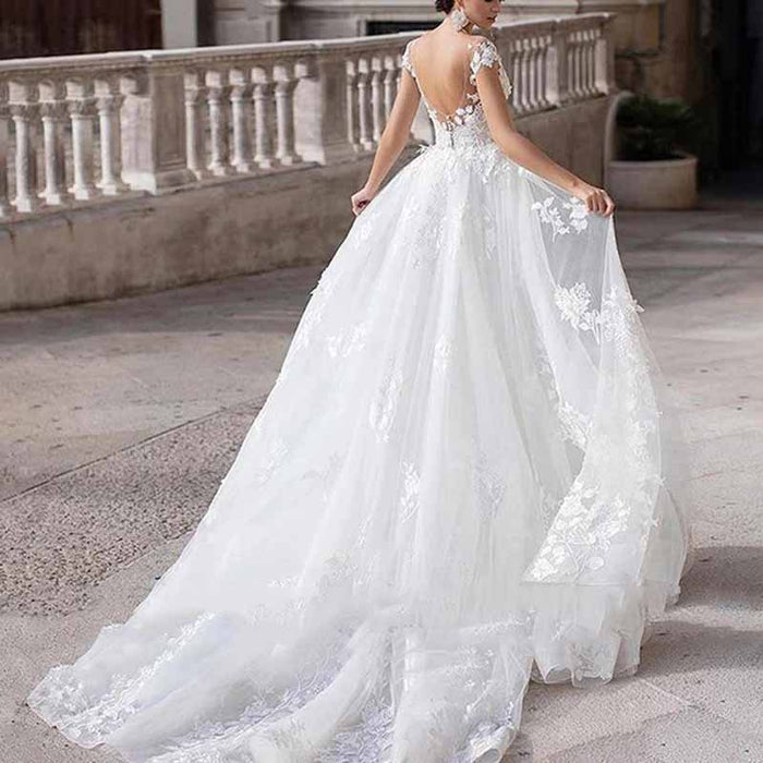 Elegant romantic lace wedding dress with sleeves featuring a flowing train and intricate lace details