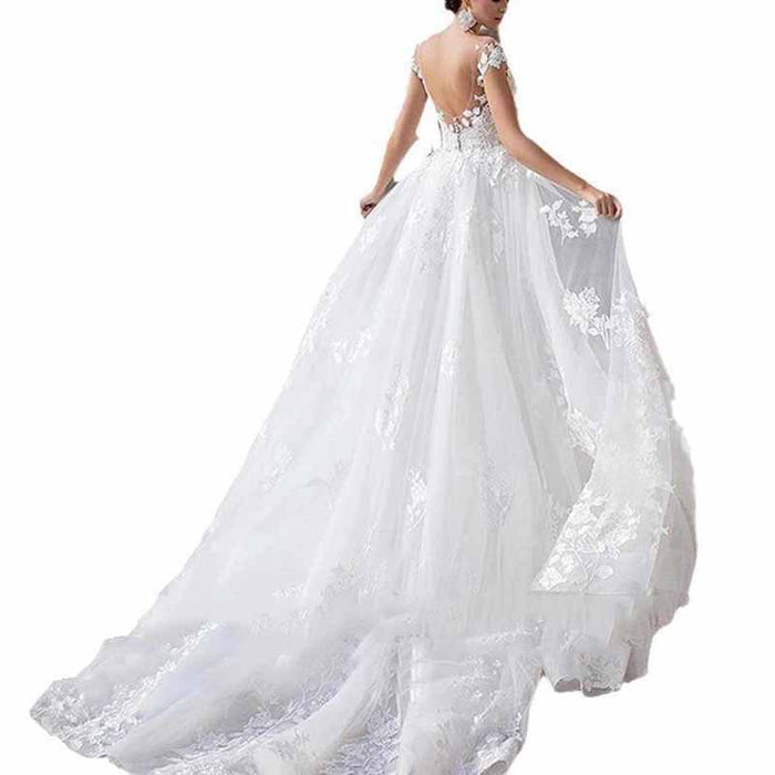 Elegant romantic lace wedding dress with sleeves featuring a flowing train and intricate floral details