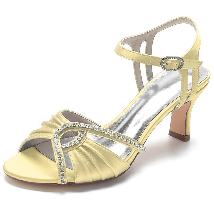 Yellow sandal with rhinestone straps on a white background